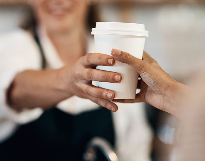 barista handing a customer a cup of coffee